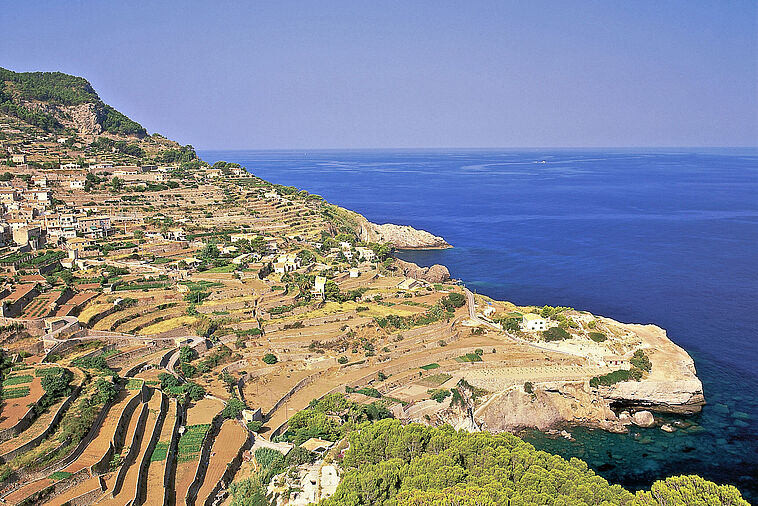 Ansicht einer Steilküste mit Häusern und Blick auf das Meer