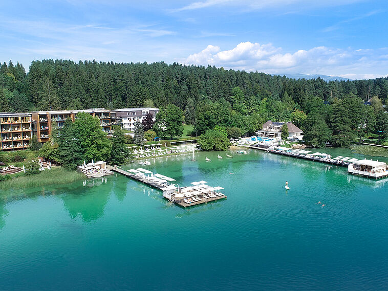 Blick auf ein Hotel mit See im Vordergrund