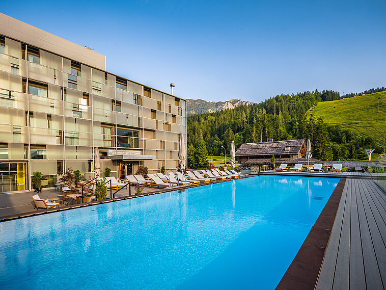 Ansicht auf das Hotel mit einem Pool im Vordergrund
