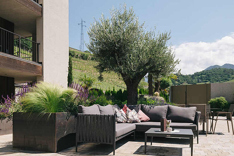 Blick über eine Terrasse mit Loungemöbeln