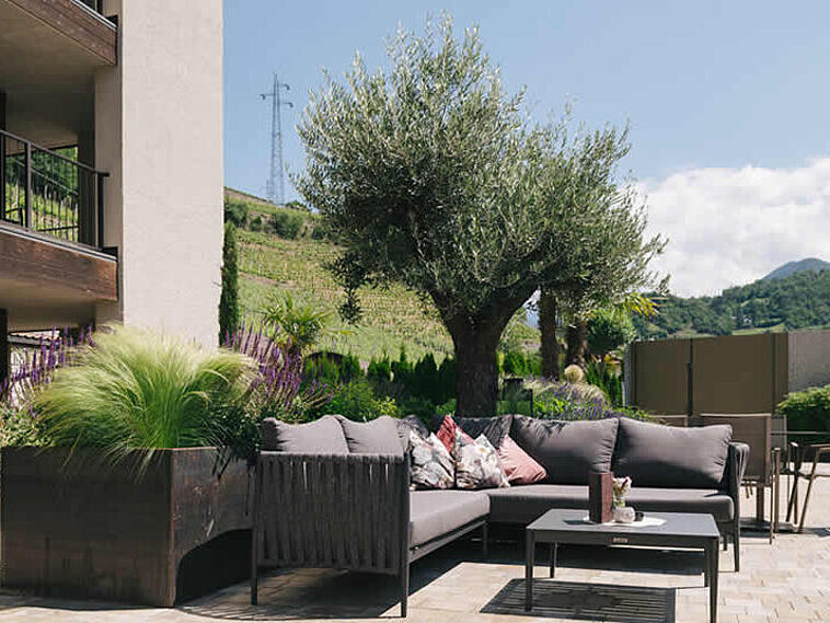Blick über eine Terrasse mit Loungemöbeln