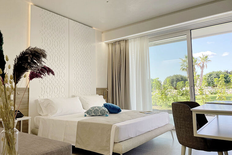 Blick in ein helles Zimmer mit Doppelbett