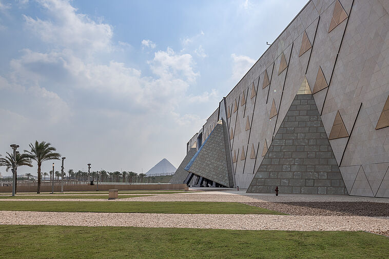 Außenfassade des neuen Grand Egyptian Museum mit Pryamide im Hintergrund