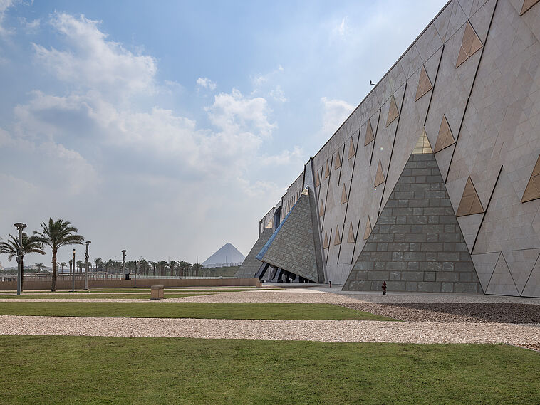 Außenfassade des neuen Grand Egyptian Museum mit Pryamide im Hintergrund