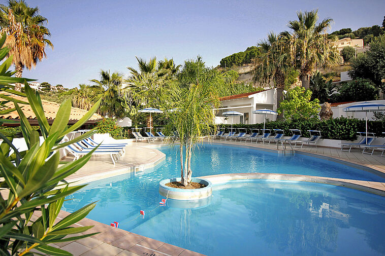 Blick auf einen Pool mit Palmen