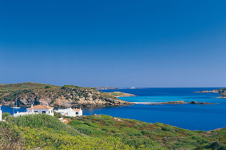 Blick über eine Bucht mit blauem Meer im Hintergrund