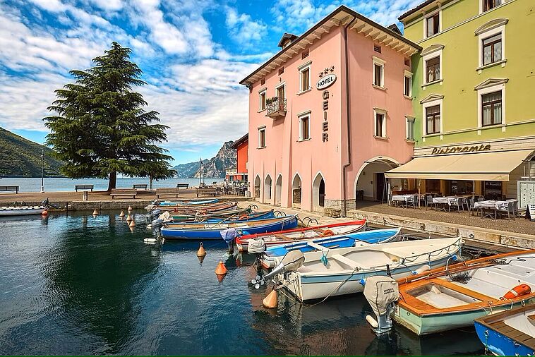 Blick auf ein Hotel mit dem Gardasee im Vordergrund