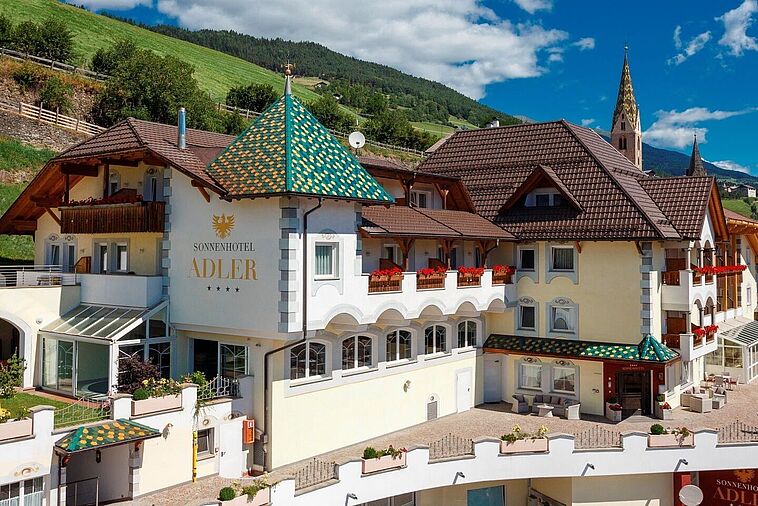 Außenansicht des Sonnenhotel Adler mit Dolomiten im Hintergrund
