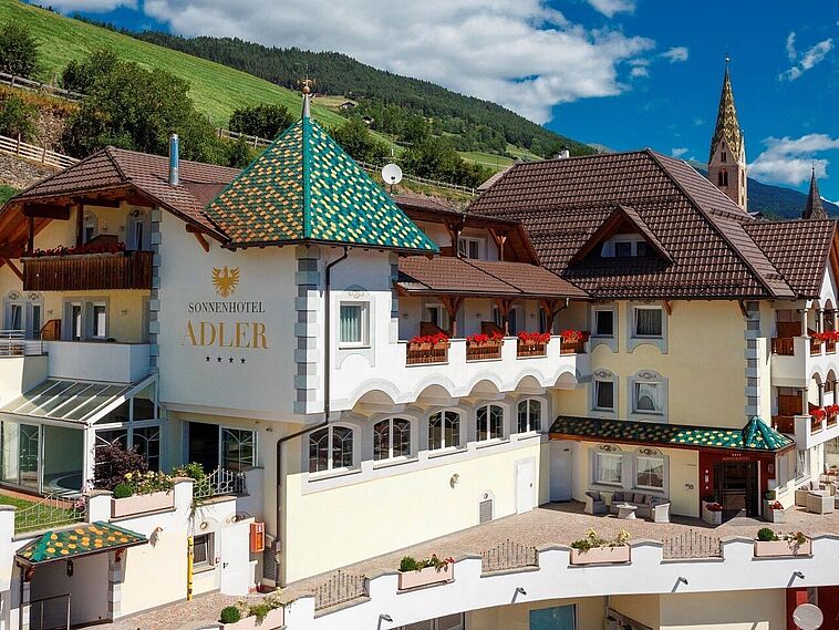 Außenansicht des Sonnenhotel Adler mit Dolomiten im Hintergrund
