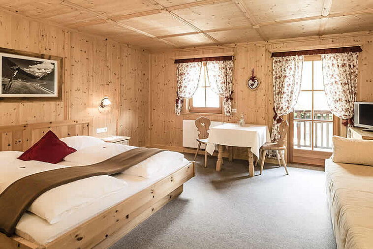 Blick in ein rustikales Doppelzimmer mit viel Holz