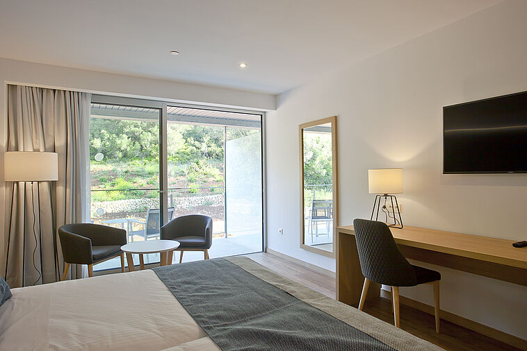 Blick in ein Doppelzimmer mit Balkon im Hintergrund