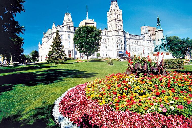 Blick über eine Rasenfläche auf das Parlamentsgebäude von Quebec