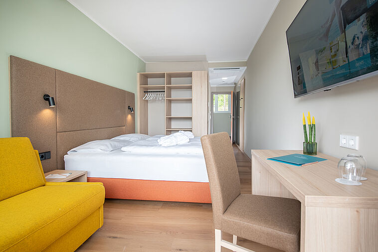 Blick in ein Doppelzimmer mit zwei Betten und einem Schrank
