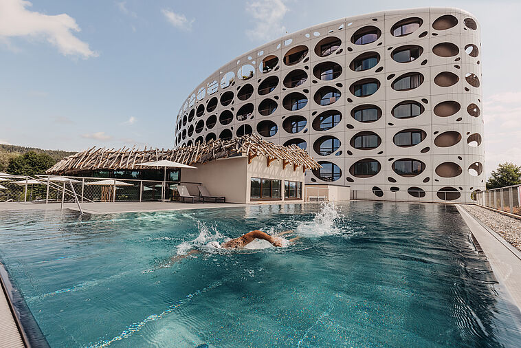 Außenansicht des Seepark Resorts Wörthersee mit Pool im Vordergrund