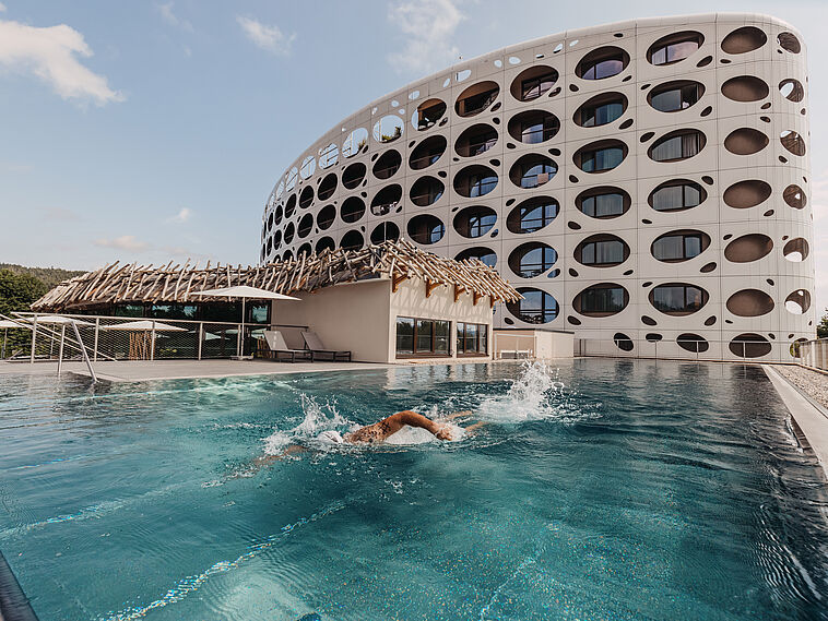 Außenansicht des Seepark Resorts Wörthersee mit Pool im Vordergrund