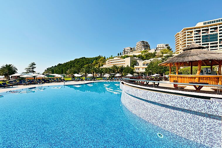 Blick über einen Pool auf ein Hotel