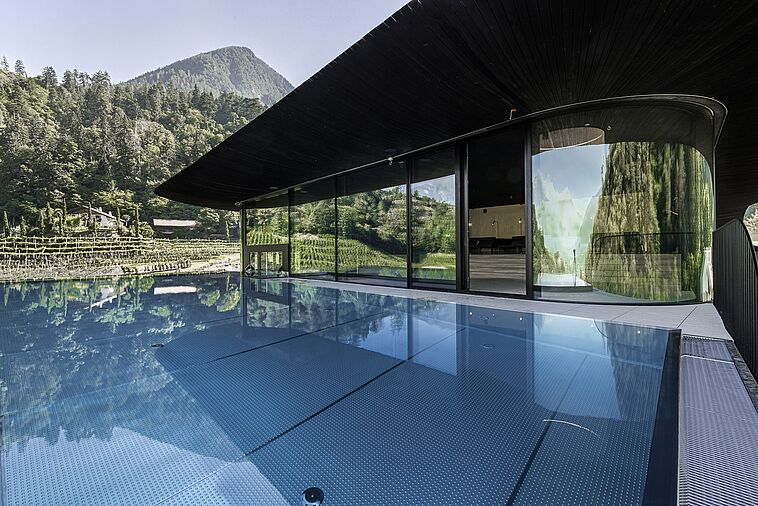 Blick über einen Außenpool am Hotel mit Berg im Hintergrund
