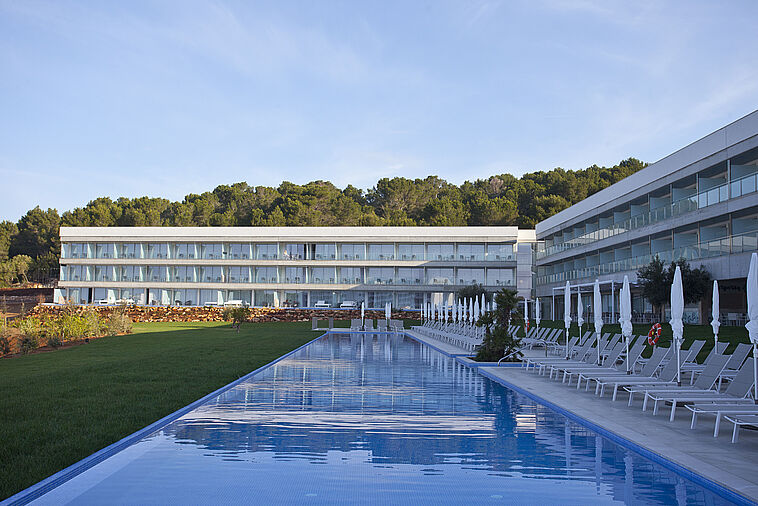 Blick über einen Pool auf eine Hotelanlage