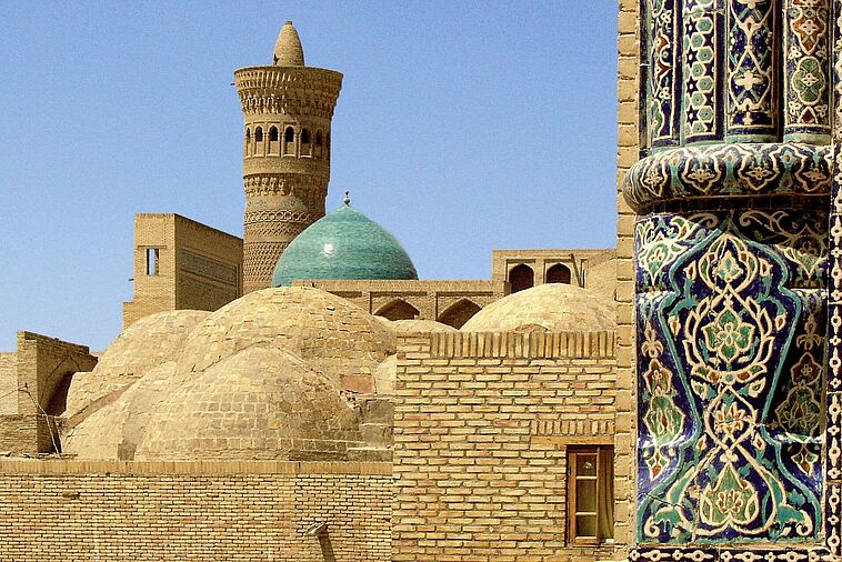 Blick auf eine Stadt mit alter Stadtmauer und Minarett