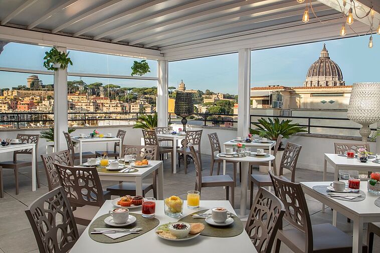 Terrasse des Hotels Elegance in Rom mit gedekcten Tischen