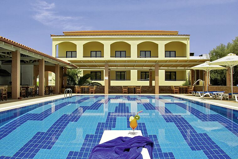 Blick über einen großzügigen Pool auf ein Hotelgebäude