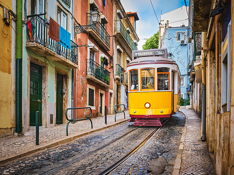 Gelbe Straßenbahn in kleiner Gasse in Lissabon