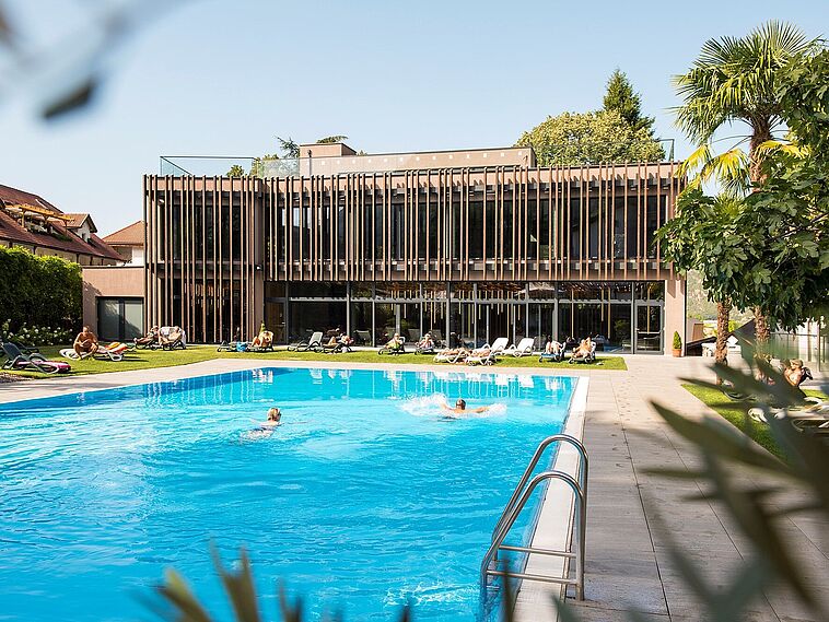 Blick über einen großen Pool auf die Fassade des Hotels