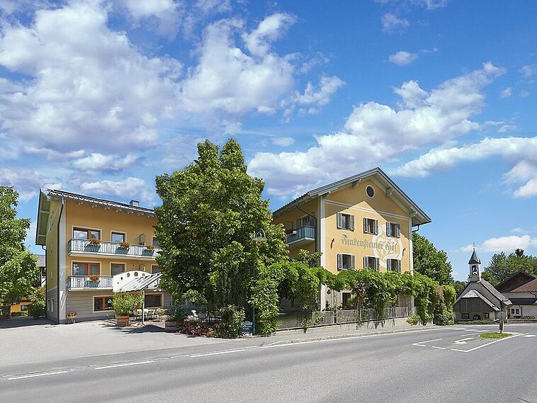 Blick auf ein Hotel von der Straße aus mit Baum davor