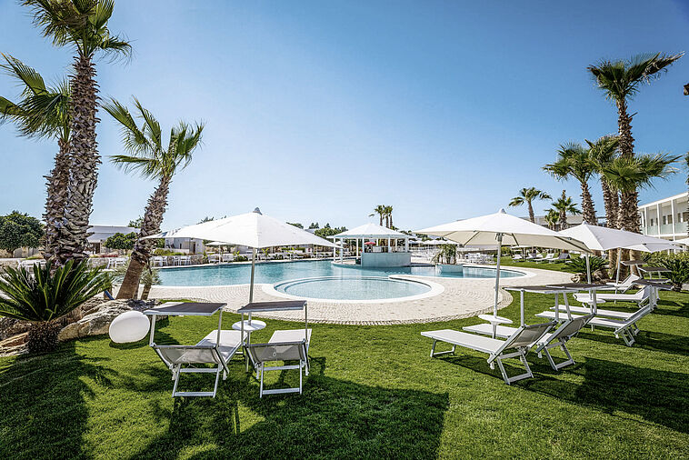 Blick auf einen Pool mit Garten im Vordergrund