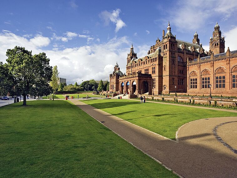 Blick über eine Rasenfläche mit viktorianischem großen Gebäude
