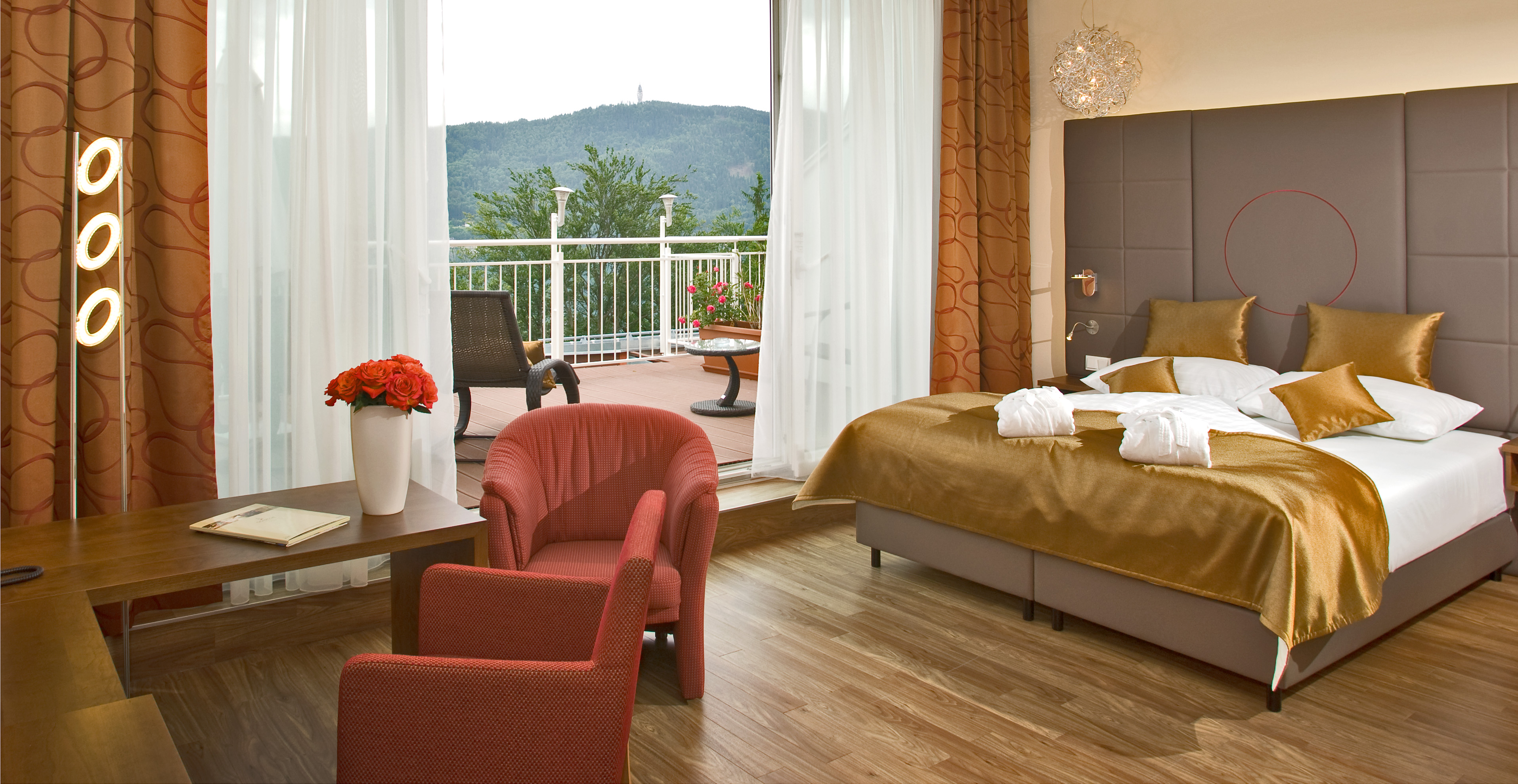 Blick in ein Doppelzimmer mit Bett und Sitzecke
